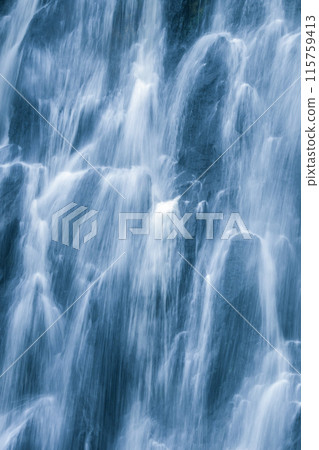 The water flows down from the rock cliff. It hits the cliff and creates mist The water flows down from the rock cliff. It hits the cliff and creates mist 115759413
