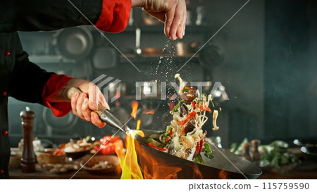 Freeze Motion of Wok Pan with Flying Asian Meal in the Air. Freeze Motion of Wok Pan with Flying Asian Meal in the Air. 115759590