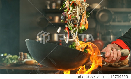 Freeze Motion of Wok Pan with Flying Asian Meal in the Air. Freeze Motion of Wok Pan with Flying Asian Meal in the Air. 115759593