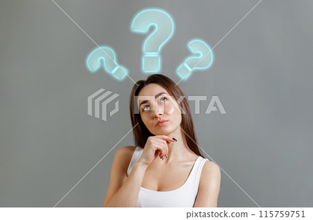 The concept of searching for ideas and information. Portrait of thoughtfully young Caucasian woman looking up at question marks. Gray background. Copy space 115759751