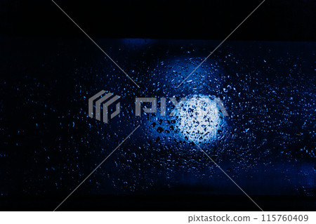 Raindrops and condensation on window at night with street lights. Cinematic dramatic background 115760409