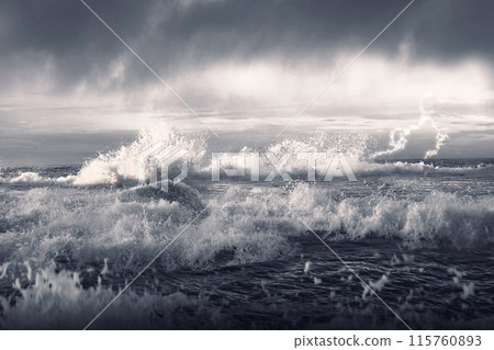 A stormy sea with large waves crashing against the shore 115760893
