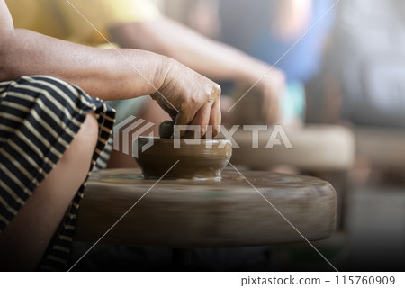 Human hand sculpting a craft from raw clay 115760909