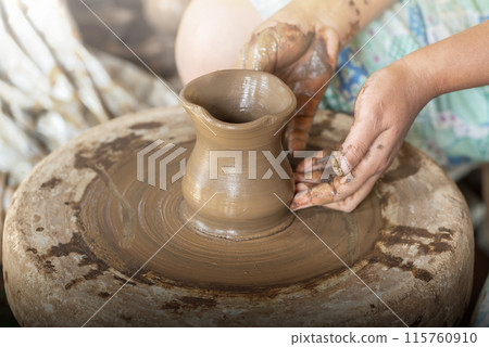 Human hand sculpting a craft from raw clay 115760910