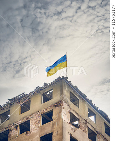 Ruined buildings adorned only by the solemn presence of a Ukraine flag 115761177