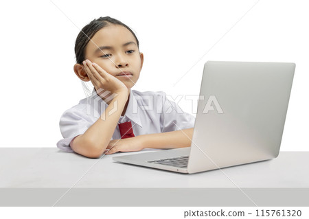 Portrait of an Asian elementary school student girl with a laptop tired of learning on the table 115761320