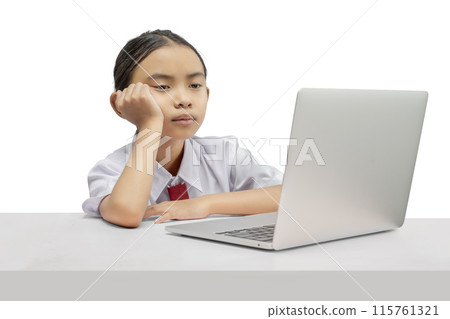 Portrait of an Asian elementary school student girl with a laptop tired of learning on the table 115761321