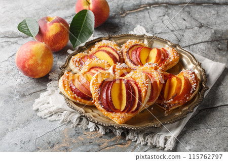 Summer dessert peach puff heart cake with ripe fruits and jam close-up in a plate. Horizontal Summer dessert peach puff heart cake with ripe fruits and jam close-up in a plate. Horizontal 115762797