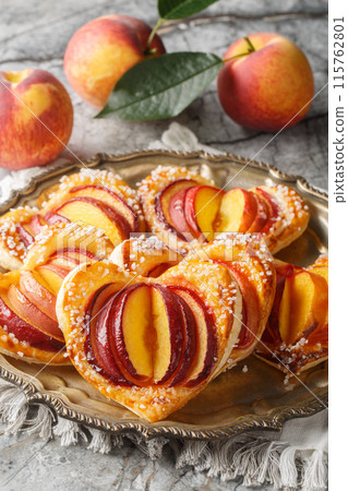 Festive peach puff in the shape of a heart with fresh fruit and jam close-up in a plate. Vertical 115762801