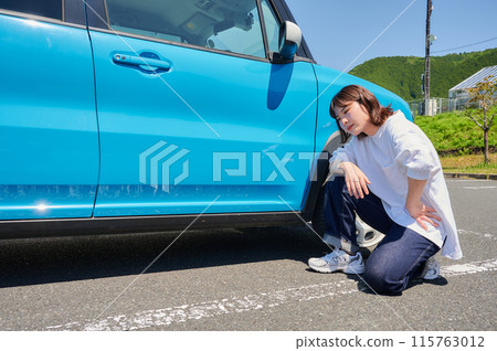 Woman holding her head in front of her car, flat tire, trouble Woman holding her head in front of her car, flat tire, trouble 115763012