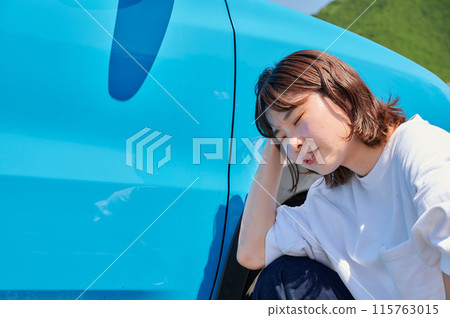 Woman holding her head in front of her car, flat tire, trouble 115763015