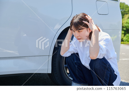 Woman holding her head in front of her car, flat tire, trouble Woman holding her head in front of her car, flat tire, trouble 115763065