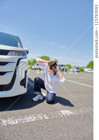 Woman holding her head in front of her car, flat tire, trouble Woman holding her head in front of her car, flat tire, trouble 115763093