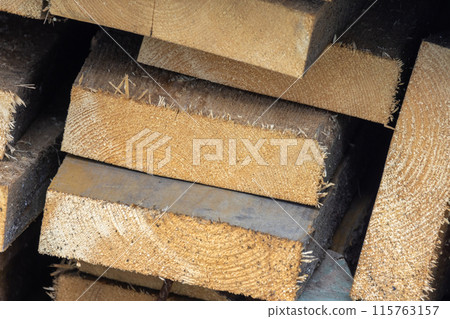 Stacked rough wooden boards close up photo, construction wood Stacked rough wooden boards close up photo, construction wood 115763157
