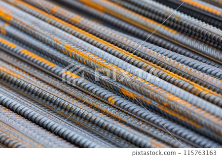 Stacked construction iron rods with rust spots, abstract industrial background 115763163