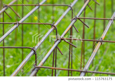 Reinforcement cages lay on green grass at construction site Reinforcement cages lay on green grass at construction site 115763175