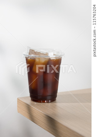 Iced americano in clear cup on wooden table. Iced americano in clear cup on wooden table. 115763204