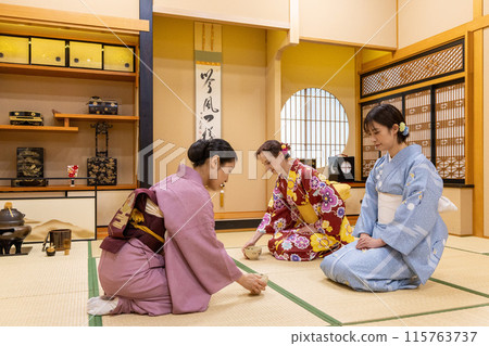 Foreign female tourists in kimonos experiencing a tea ceremony and a Japanese female guide Foreign female tourists in kimonos experiencing a tea ceremony and a Japanese female guide 115763737