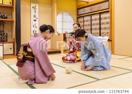 Foreign female tourists in kimonos experiencing a tea ceremony and a Japanese female guide Foreign female tourists in kimonos experiencing a tea ceremony and a Japanese female guide 115763744