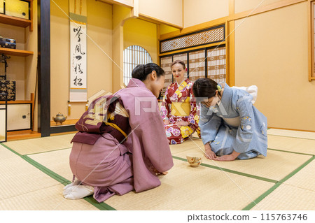 Foreign female tourists in kimonos experiencing a tea ceremony and a Japanese female guide 115763746
