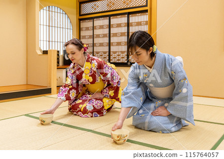 Foreign female tourists and Japanese women in kimonos enjoying a tea ceremony experience Foreign female tourists and Japanese women in kimonos enjoying a tea ceremony experience 115764057