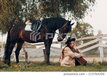 Cowgirl in brown clothes with her horse at outdoors ranch Cowgirl in brown clothes with her horse at outdoors ranch 115764200