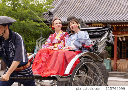 一位外國女子和一位穿著和服的日本女子乘坐人力車遊覽淺草 115764999