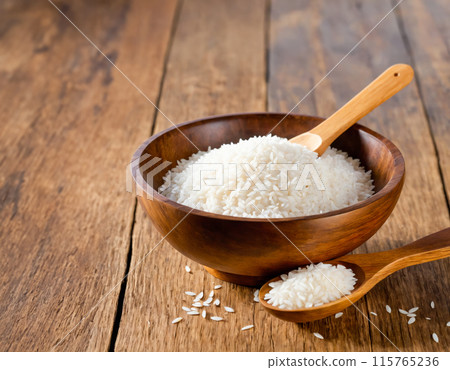 Raw White Rice in Wooden Bowl with Spoon Raw White Rice in Wooden Bowl with Spoon 115765236
