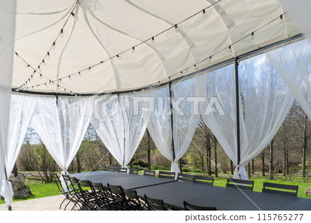 Party tent, white garden party, wedding entertainment tent in modern garden. High quality photo 115765277