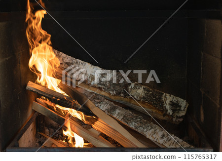 Burning fireplace. Burning birch logs in the fireplace. Warmth in cold weather Burning fireplace. Burning birch logs in the fireplace. Warmth in cold weather 115765317