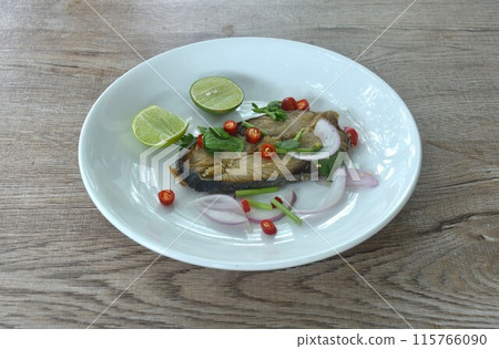 salty dry Indo-Pacific king mackerel fish topping chop shallot and chili with slice lemon salad on plate salty dry Indo-Pacific king mackerel fish topping chop shallot and chili with slice lemon salad on plate 115766090