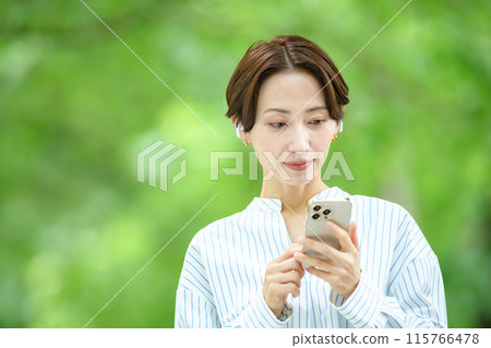 一個女人在新鮮的綠色中聽音樂 115766478