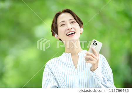 A woman listening to music in the fresh green A woman listening to music in the fresh green 115766483