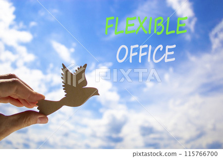 Flexible office symbol. Concept words Flexible office on beautiful sky. Beautiful blue sky cloud background. Businessman hand with wooden bird. Business Flexible office concept. Copy space. 115766700