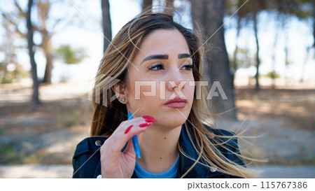Woman Touching Her Hair In The Park Woman Touching Her Hair In The Park 115767386