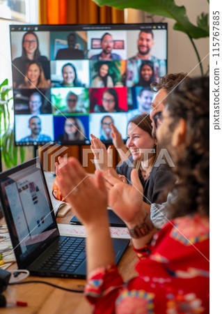 A group of people are clapping on a laptop screen 115767885