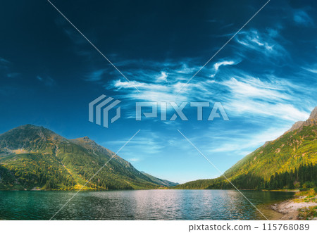 Tatra National Park, Poland. Famous Mountains Lake Morskie Oko Or Sea Eye Lake In Summer Morning. Beautiful Sunrise Sunrays Above Tatras Lake Landscape Tatra National Park, Poland. Famous Mountains Lake Morskie Oko Or Sea Eye Lake In Summer Morning. Beautiful Sunrise Sunrays Above Tatras Lake Landscape 115768089