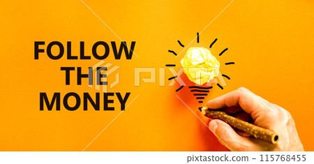 Follow the money symbol. Concept words Follow the money on beautiful orange paper. Beautiful orange background. Light bulb icon. Businessman hand. Business and follow the money concept. Copy space. Follow the money symbol. Concept words Follow the money on beautiful orange paper. Beautiful orange background. Light bulb icon. Businessman hand. Business and follow the money concept. Copy space. 115768455