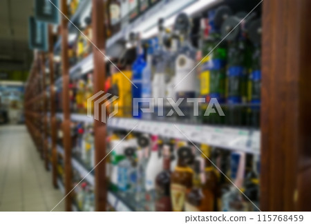 Alcohol showcase blurred background. Blurred abstract background of shelf in supermarket. Concept. Alcohol showcase blurred background. Blurred abstract background of shelf in supermarket. Concept. 115768459