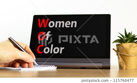 WOC women of color symbol. Concept words WOC women of color on beautiful black tablet. Beautiful white background. Businessman hand. Business WOC women of color social issues concept. Copy space. 115768477