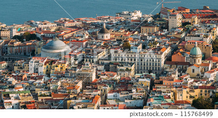 Naples, Italy. Top View Cityscape Skyline With Famous Landmarks And Part Of Gulf Of Naples With Ships In Sunny Day. Many Old Churches And Temples Naples, Italy. Top View Cityscape Skyline With Famous Landmarks And Part Of Gulf Of Naples With Ships In Sunny Day. Many Old Churches And Temples 115768499