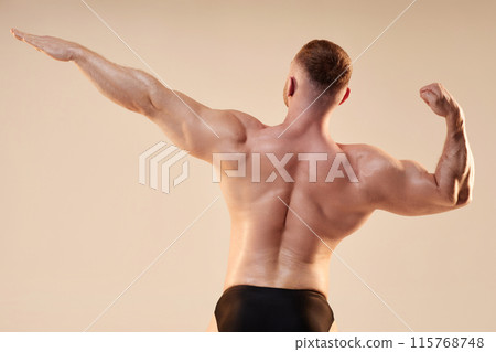 Medium shot of unrecognizable strong bodybuilder performing rear archer pose in studio on neutral background, copy space Medium shot of unrecognizable strong bodybuilder performing rear archer pose in studio on neutral background, copy space 115768748