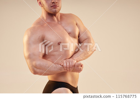 Cropped medium shot of bodybuilders upper body muscles in side chest pose with pumped biceps isolated over neutral background, copy space 115768775