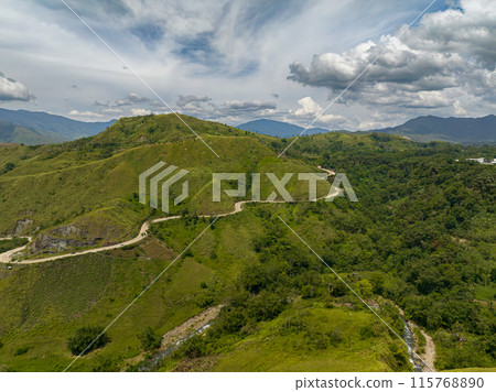 Tropical mountain valley and mountain asphalt road. Rainforest with flowing water over river. Mindanao, Philippines. Tropical mountain valley and mountain asphalt road. Rainforest with flowing water over river. Mindanao, Philippines. 115768890