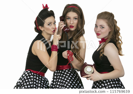 Three beautiful retro girls. Group of women with retro telephone. The girlfriends are discussing the telephone conversation. Gossips. Three beautiful retro girls. Group of women with retro telephone. The girlfriends are discussing the telephone conversation. Gossips. 115769639