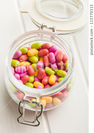 Colorful hard mint Candies in jar on white table. Colorful hard mint Candies in jar on white table. 115770315