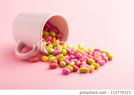 Colorful hard mint Candies in cup on pink background. 115770323