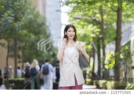 A woman in her 30s walking down the street A woman in her 30s walking down the street 115771503