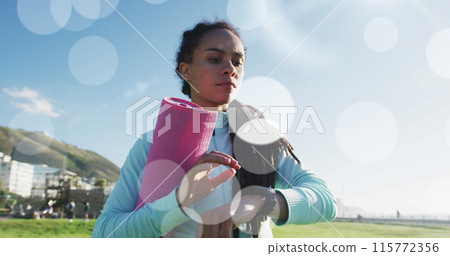 Multiple white spots floating against african american fit woman using smartwatch at sports field 115772356