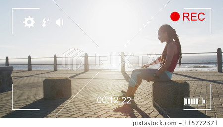 Digital camera interface against tired african american fit woman sitting on the promenade 115772371